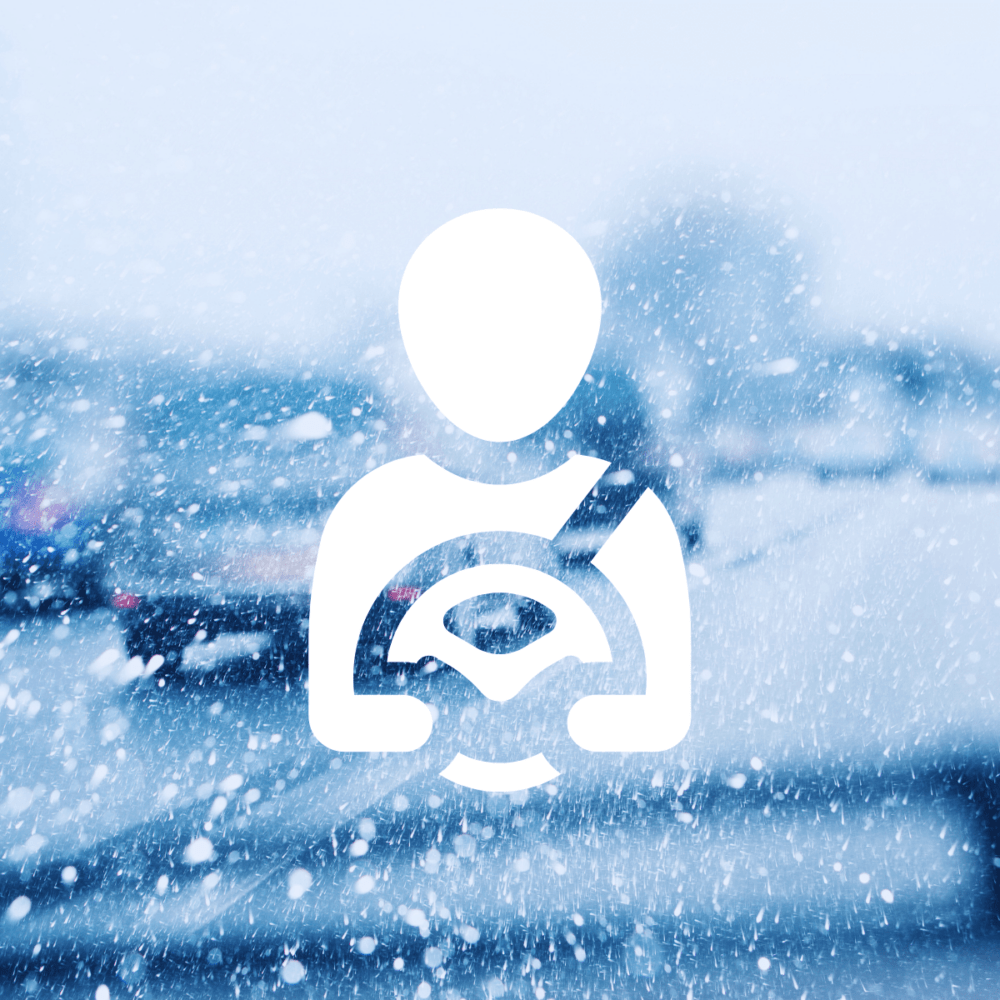 An icon of a person with a seatbelt and steering wheel is overlaid on a blurred snowy street scene, capturing the essence of winter driving amidst cars gliding by.